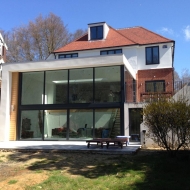 At lower-ground level the sliding doors open up from the centre, whilst above the doors on the return connect the extension and patio